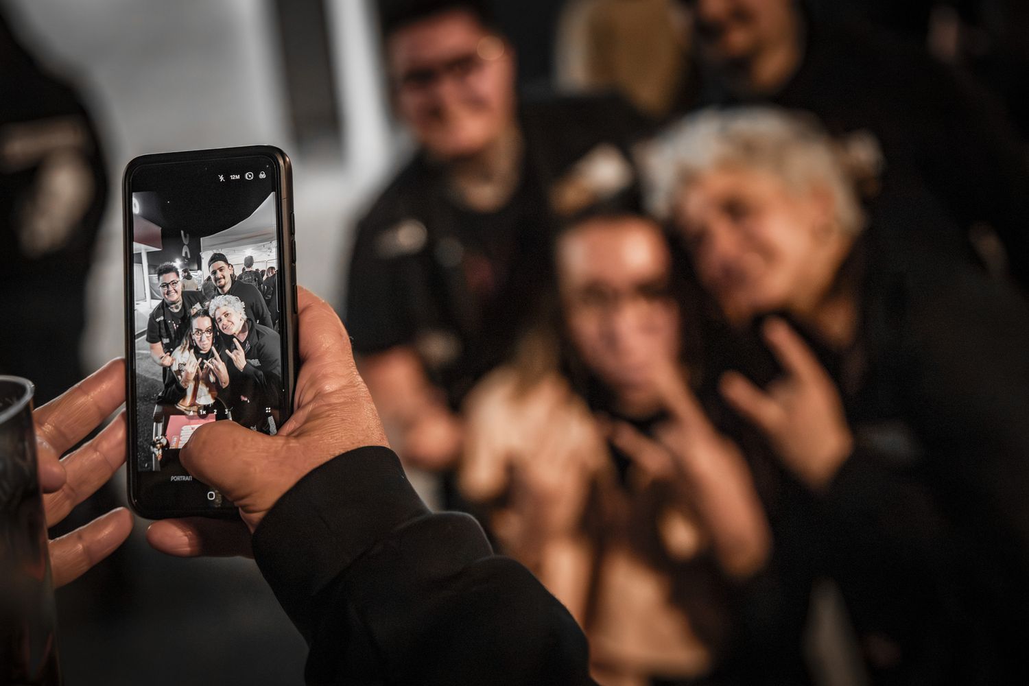 Ambiance public en festival, spectateurs photographiant le groupe